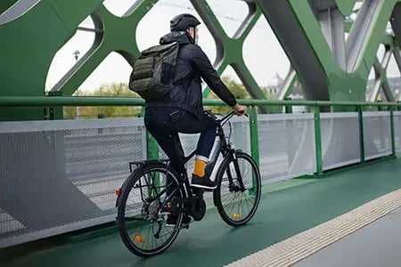 ManRidingeBikeonBridge.jpg